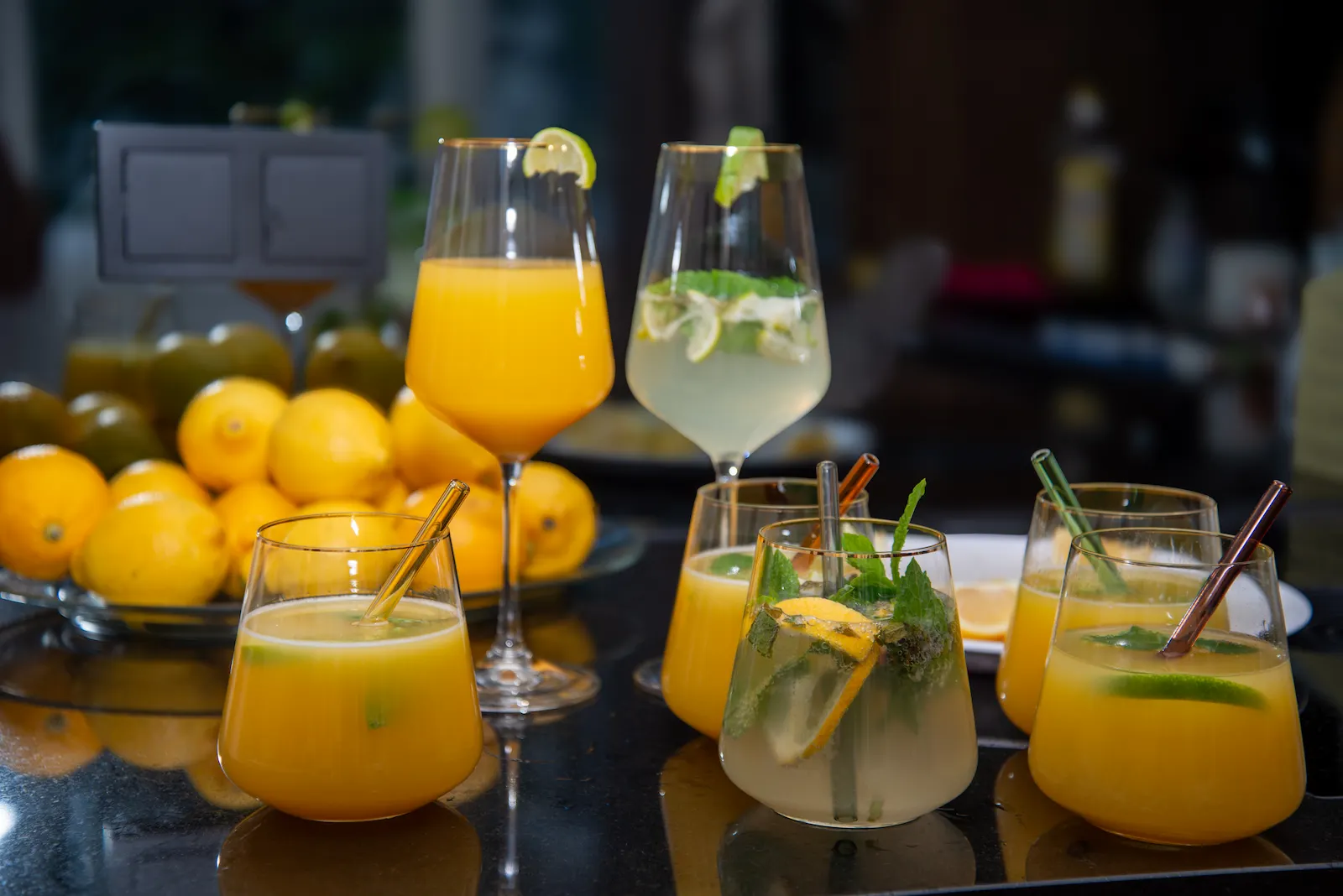 Kollagen richtig einnehmen: Das Pulver lässt sich in Saft einrühren – Gläser mit Orangensaft und Limonade